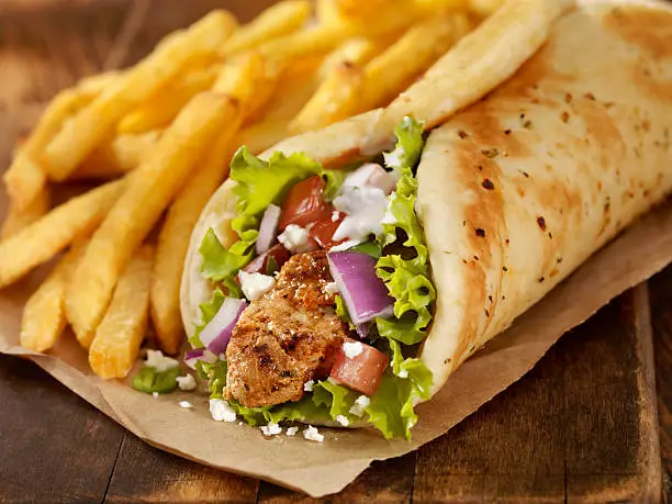 Pork Souvlaki Pita Wrap with Lettuce, Tomatoes, Red Onions, Feta Cheese, Tzatziki Sauce and a Side of french Fries -Photographed on Hasselblad H3D-39mb Camera