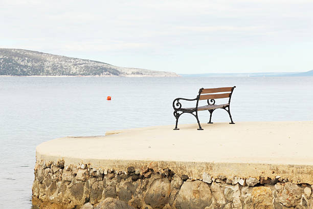 istock brown  empty bench on concrete floor against mediterranean ocean 171579986