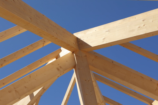 a new house in shell construction with a roof truss made of wooden beams