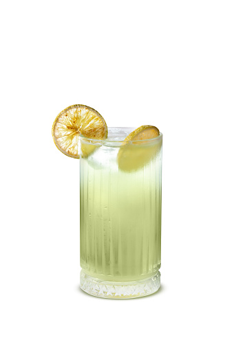A vibrant cool lime drink, gently resting in a glass, showcased against a crisp white background.