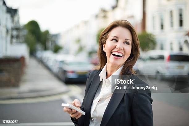 Photo libre de droit de Joyeuse Femme Daffaires À Laide De La Technologie banque d'images et plus d'images libres de droit de 45-49 ans