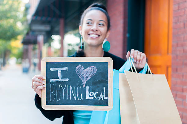 Woman holding sign that says I love buying local  stock photo