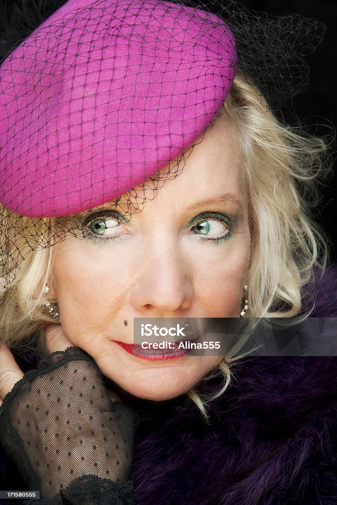 Piękna Starsza kobieta na sobie kapelusz i boa na czarnym - Zbiór zdjęć royalty-free (Kapelusz)