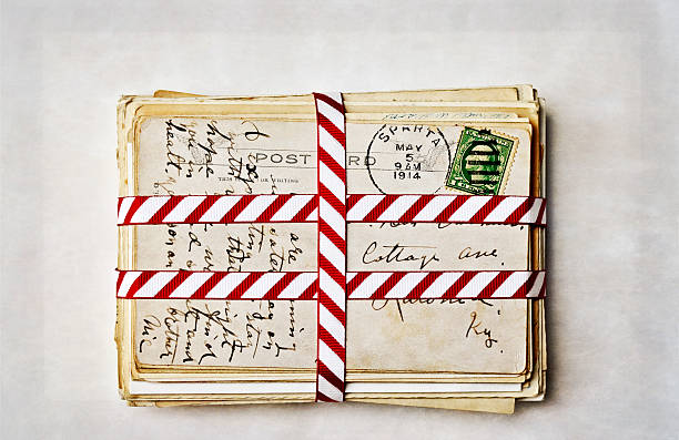 Old Postcards with Ribbon A stack of old postcards with Christmas ribbon.  Texture and border added. 1914 stock pictures, royalty-free photos & images
