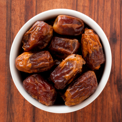 Top view of white bowl full of dates