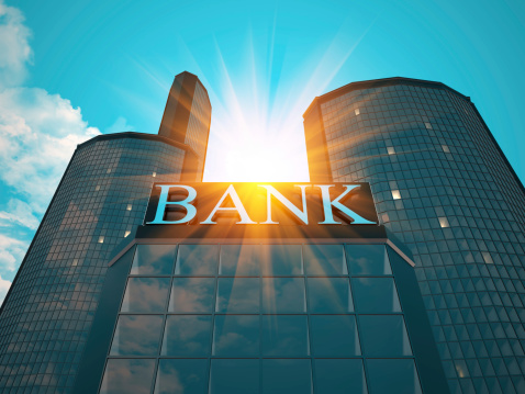 Metallic sign on a building, with the word bank. And sky reflection with sun flaressky texture my own