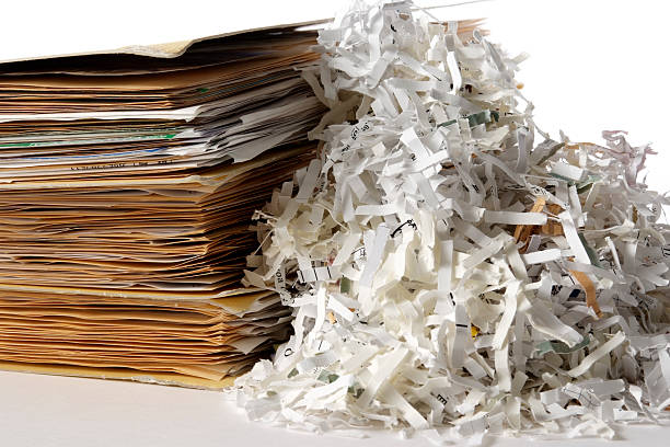 Isolated shot of shredded documents with folder on white background Shredded documents with stacked of with folder isolated on white background. destruction stock pictures, royalty-free photos & images