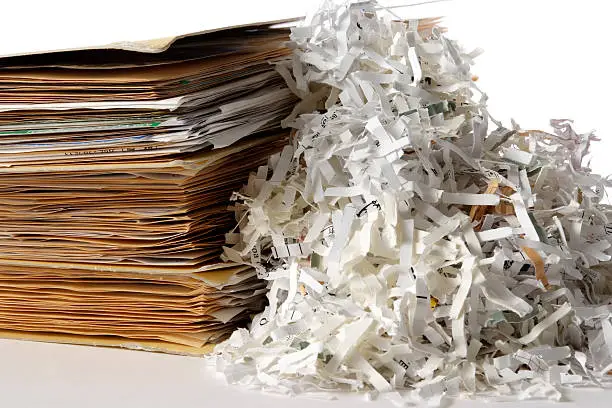 Shredded documents with stacked of with folder isolated on white background.