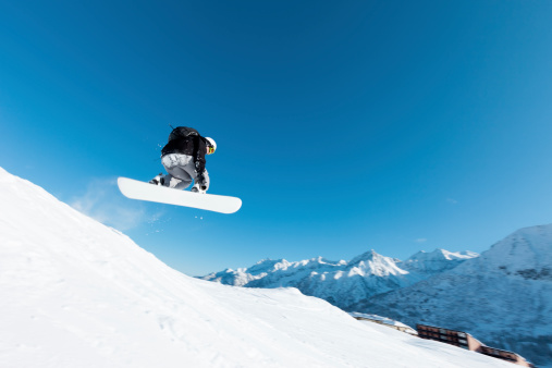 Snowboarder at high speed jumping against ,  blue sky and wave of snowSEE ALSO:
