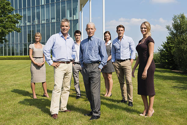Confident Business People Standing At Lawn Full length portrait of confident business people standing at lawn. organized group photos stock pictures, royalty-free photos & images