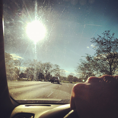 a person driving on a clear sunny day. shot with an iphone 4s using instagram filters. 