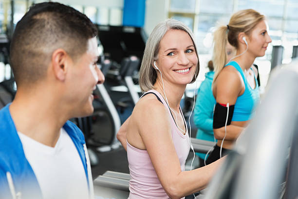 istock Man and woman talking in gym on treadmills while exercising 171581135