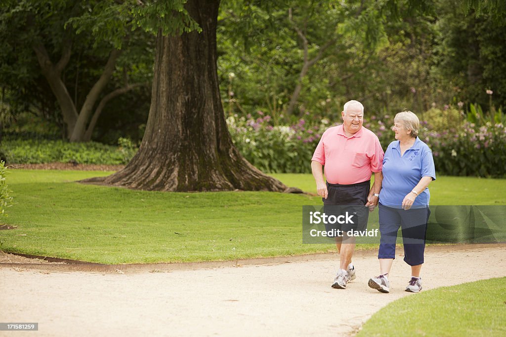 Senior Pareja caminando en un parque - Foto de stock de Gordo - Complexión libre de derechos