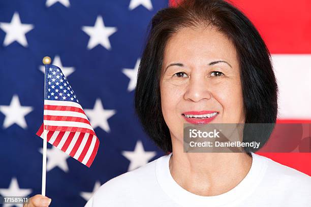 Foto de Madura Mulher Asiática Segurando Uma Pequena Bandeira Dos Eua e mais fotos de stock de 60 Anos