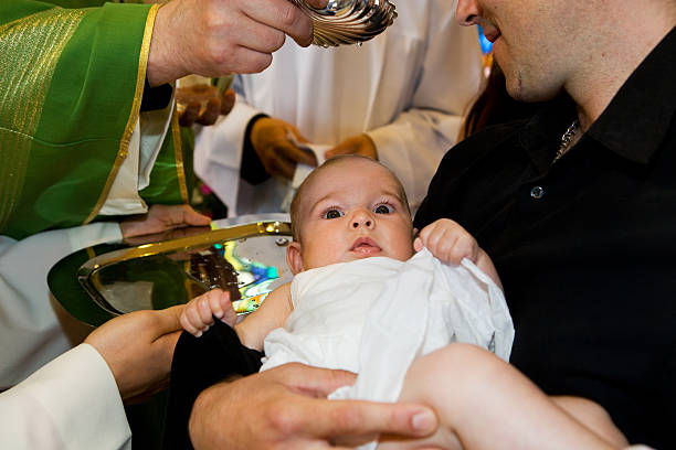 w church.priest jest baptizing małe dziecko. - chrzestny zdjęcia i obrazy z banku zdjęć