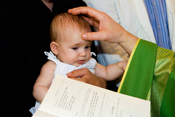 Closeup of christening objects with white flower ribbon