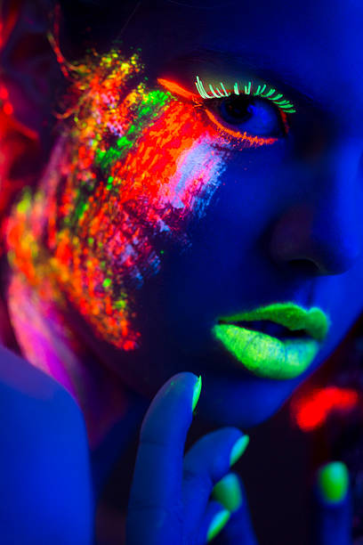 istock Women Portrait with Glowing Multi Colored makeup in black light 171581706