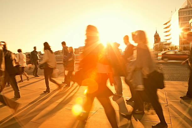 business commuters walking home after work, sunset backlit, blurred motion - värme bildbanksfoton och bilder