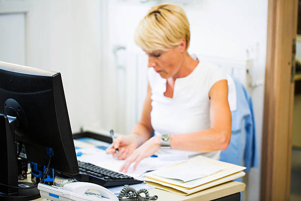 istock Nurse in her office,her daily paper work... 171581887