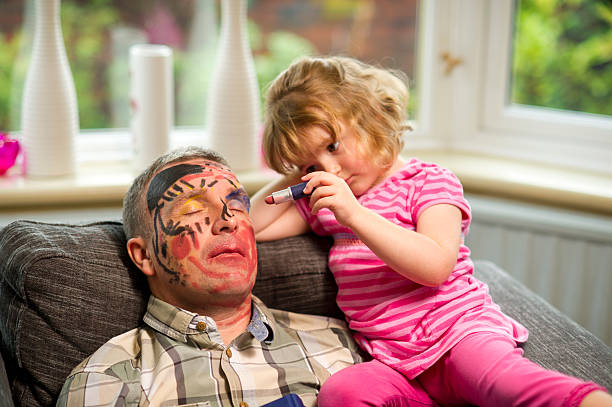 daddy make up time little girl has fun with a sleeping father humor stock pictures, royalty-free photos & images