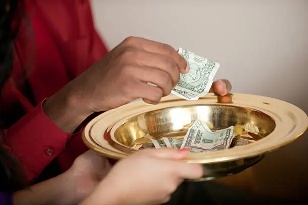 People giving tithes and offerings in church