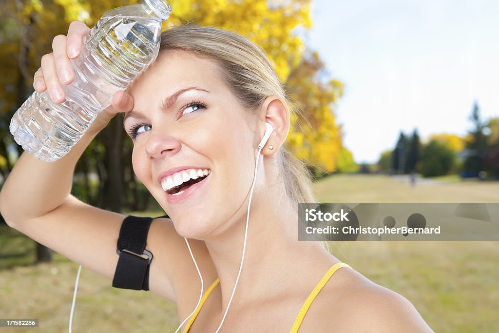 Lächelnd weibliche Läufer holding Flasche Wasser - Lizenzfrei 20-24 Jahre Stock-Foto