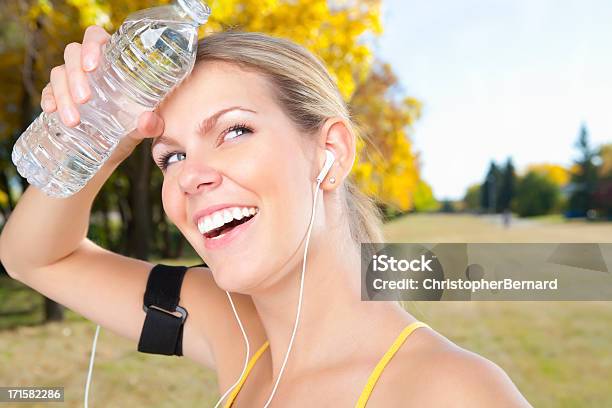 Foto de Corredor Feminino Sorridente Segurando Garrafa De Água e mais fotos de stock de 20-24 Anos