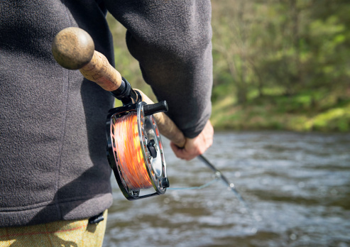 A man fly fishing in a Scottish river.