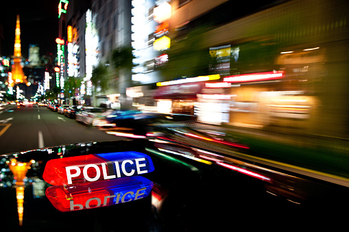 A police car with flashing lights going to quickly in the city
