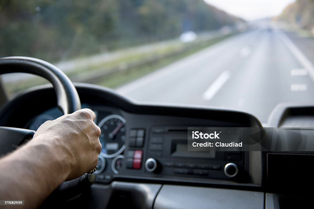 Truck driver on german autobahn Middle aged man holding steering wheel.See other photos of that model: Truck Driver Stock Photo