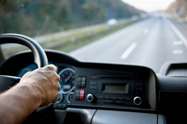 Truck driver on german autobahn Middle aged man holding steering wheel.See other photos of that model: driving steering wheel stock pictures, royalty-free photos & images