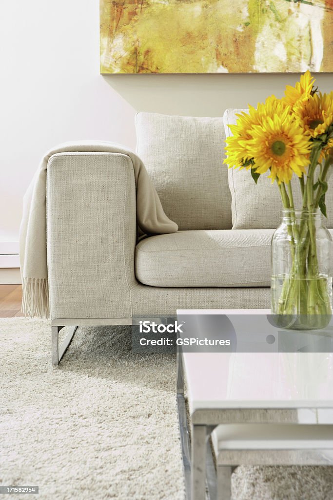 Empty modern living room Empty modern living room with white rug and a vase with sunflowers arrangement on a coffee table.  Vertical composition. Flower Stock Photo