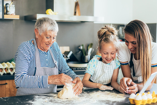 Grandmother holding newborn baby. Family reunion. Senior woman with little child. Grandma seeing grandchild on Thanksgiving celebration dinner. Kids visit grandparents. Elderly lady with infant kid.