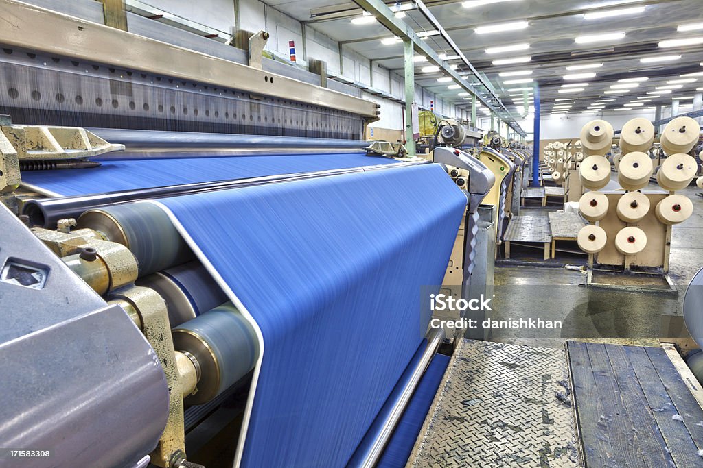 Denim Textile Industry - Big Weaving Room, HDR Weaving fabric on air jet looms in big textile weaving unit. Textile Industry Stock Photo