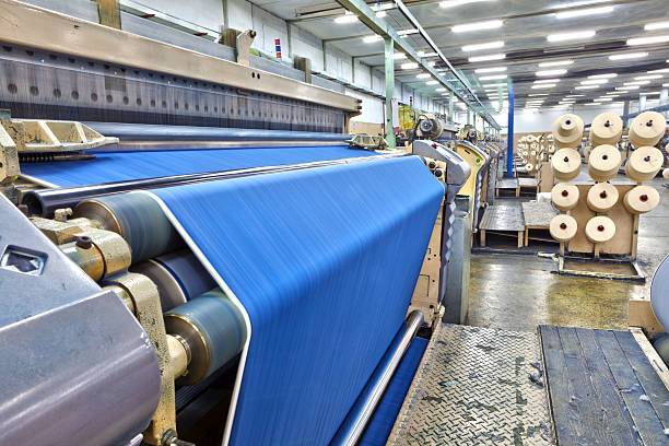 Denim Textile Industry - Big Weaving Room, HDR Weaving fabric on air jet looms in big textile weaving unit. textile industry stock pictures, royalty-free photos & images