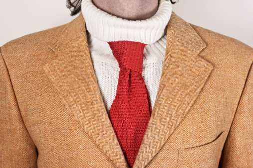 A silk necktie improperly worn over a turtleneck sweater.