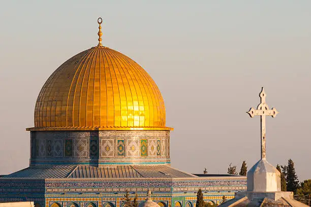 The Dome of the Rock (Islam) and the cross of a church (Christianity) in the old city of Jerusalem.