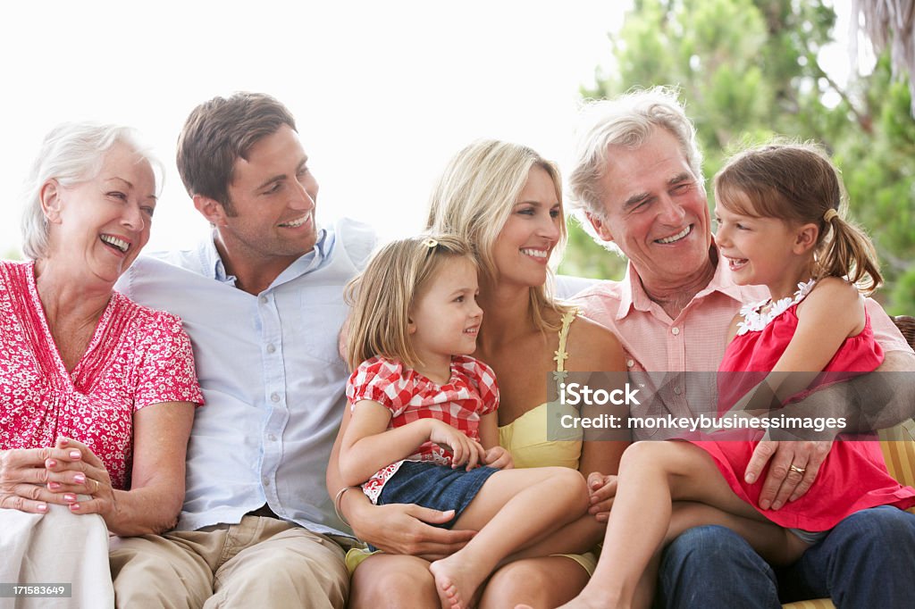 Multi Generation Family Sitting in Garden Sitz - Lizenzfrei Seniorenpaar Stock-Foto