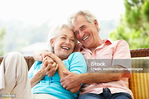 Senior Couple Sitting On Outdoor Seat Together Stock Photo - Download Image Now - Senior Couple, Senior Adult, Couple - Relationship