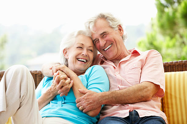 senior couple sitting on outdoor seat together - aktiva pensionärer bildbanksfoton och bilder