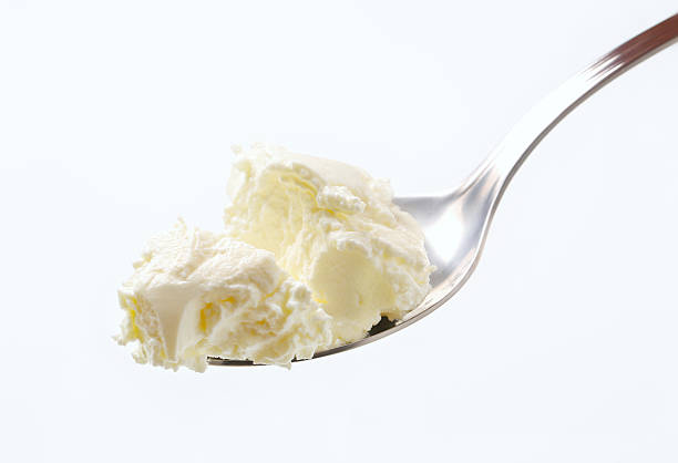 sweet cream cheese on a spoon sweet soft cream cheese with on a metal spoon cream cheese stock pictures, royalty-free photos & images