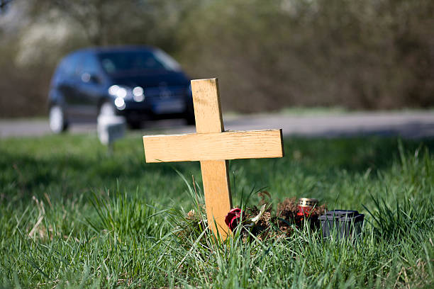 Wooden roadside memorial A wooden roadside memorial. In the background an unrecognisable car drives by the scenery. Selective focus roadside stock pictures, royalty-free photos & images