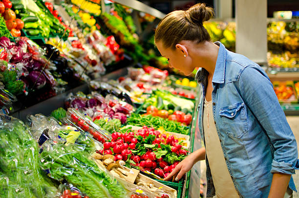 jovem mulher no supermercado - vegetable market imagens e fotografias de stock