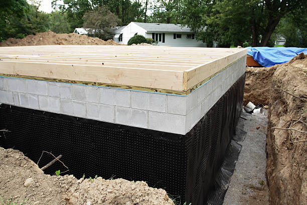 New Basement Foundation Waterproofing A suburban residential construction home addition has a new basement foundation with a durable, heavy-duty plastic basement waterproofing shroud newly installed.. waterproof stock pictures, royalty-free photos & images