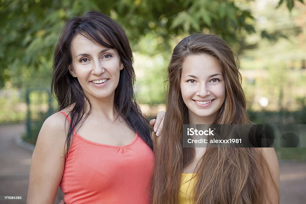 Ritratto di un sorridente Madre e figlia in posa nel parco - Foto stock royalty-free di Abbigliamento casual