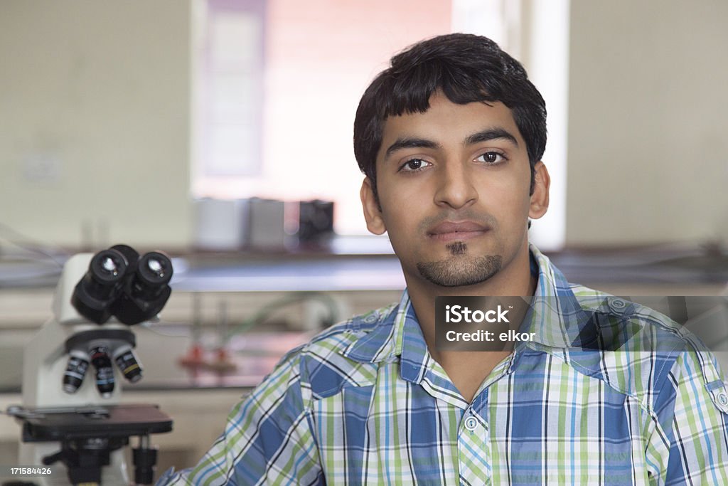 Indian estudiante con microscopio en un laboratorio - Foto de stock de Cultura hindú libre de derechos