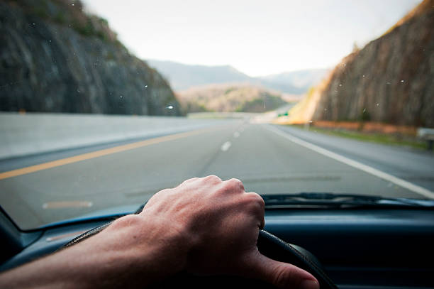 istock Driver's hand on the wheel driving down highway 171584794
