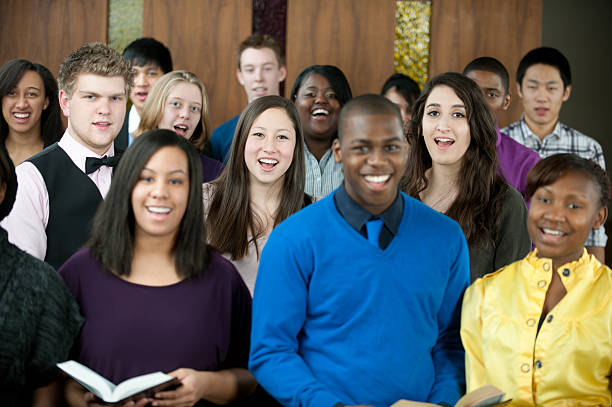 Singing hymns A diverse group of young adults singing in church. Shallow depth of field.  - Buy credits multiple churches stock pictures, royalty-free photos & images