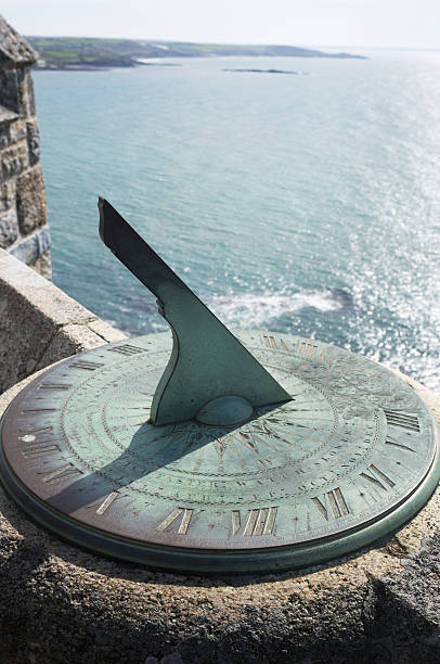 Sundial Close-up of a sundial overlooking the ocean. ancient sundial stock pictures, royalty-free photos & images