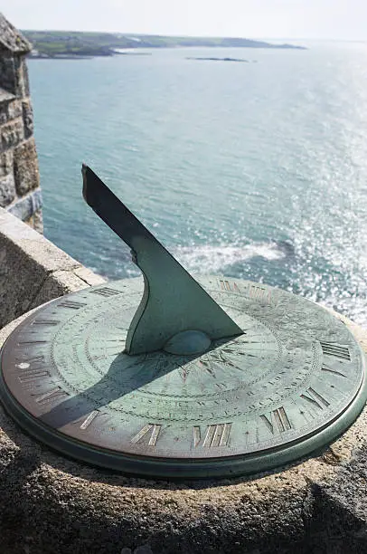 Close-up of a sundial overlooking the ocean.